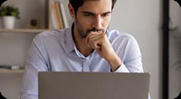 Hombre concentrado mientras consulta información en su computadora portátil