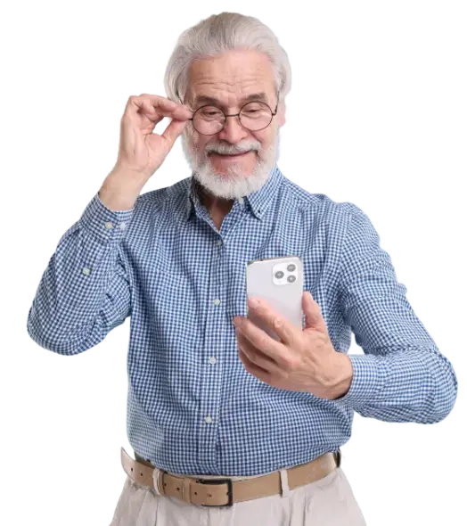 Foto de adulto mayor sonriendo mientras mira su teléfono móvil y ajusta sus lentes, vistiendo una camisa a cuadros azul sobre fondo negro.