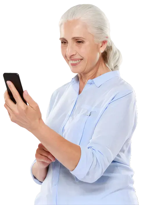 Mujer adulta mayor sonriendo mientras consulta su teléfono celular.