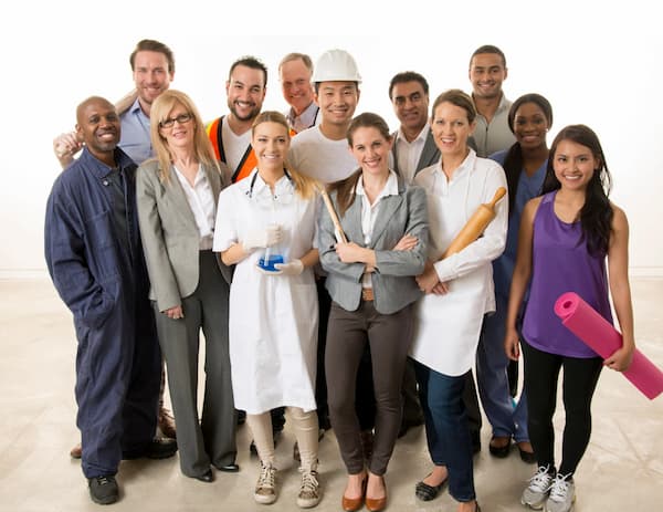 Grupo diverso de profesionales y trabajadores de diferentes oficios posando sonrientes sobre fondo blanco, incluyendo científica con matraz, chef con rodillo, mecánico, enfermera, personal de construcción y ejecutivos.